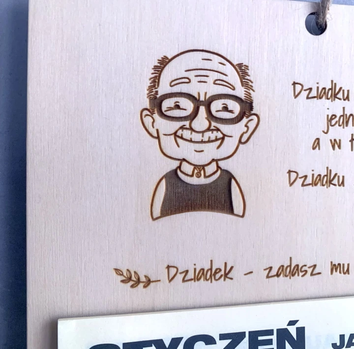 zbliżenie na grawerowaną grafikę uśmiechniętego dziadka na sklejce
