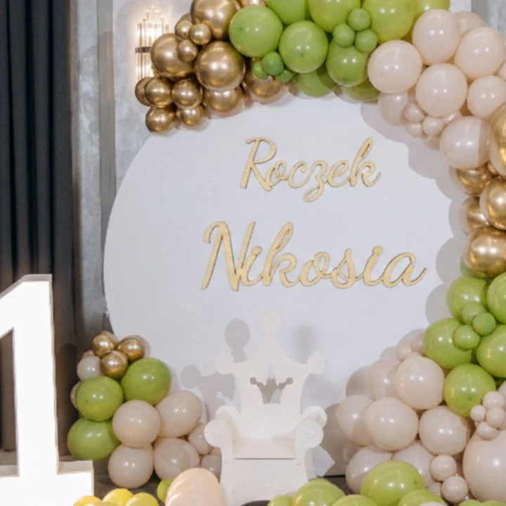 napis drewniany na ściankę balonową w zielonej kolorystyce Roczek Nikosia, drewniana dekoracja na roczek