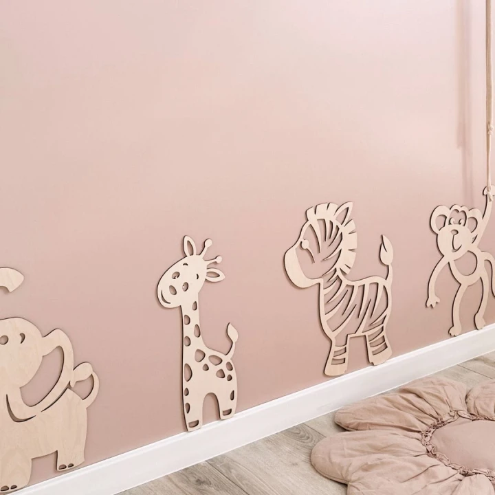 Drewniana żyrafa, słoń, zebra i małpka jako dekoracja ścienna w różowym pokoju dziecka