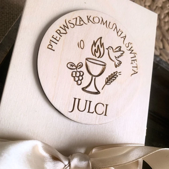 Zbliżenie na naklejony dekor 3D z grawerem kielicha, gołębicy i imieniem dziecka.