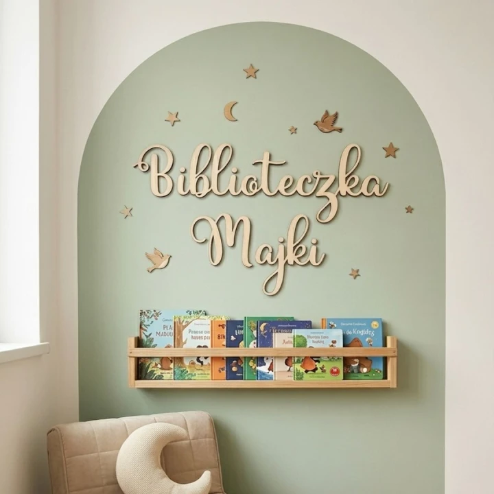 Personalizowany napis ze sklejki Biblioteczka Majki na gładkiej ścianie nad półką z książkami dla dzieci.