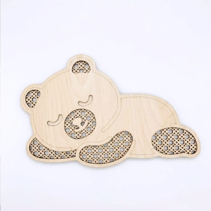 Drewniana dekoracja ścienna w kształcie śpiącego misia z ażurowym wzorem rattanu, wymiary 45x29 cm