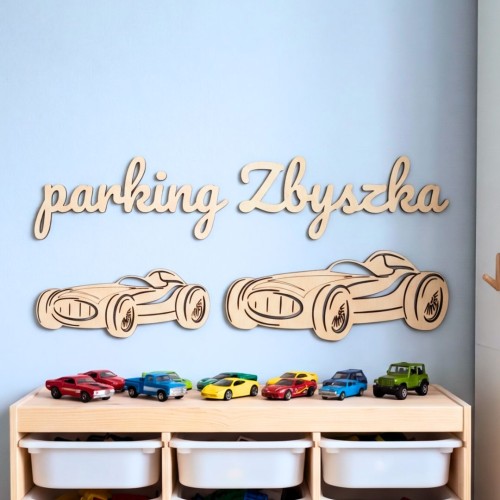 Personalizowany napis Parking Zbyszka i dwie drewniane wyścigówki nad szafką Trofast z samochodzikami.