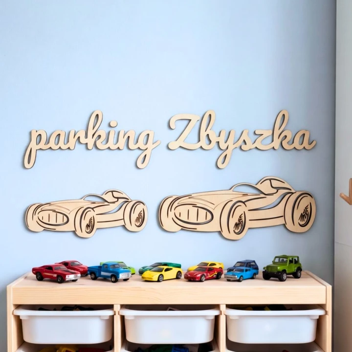 Personalizowany napis Parking Zbyszka i dwie drewniane wyścigówki nad szafką Trofast z samochodzikami.