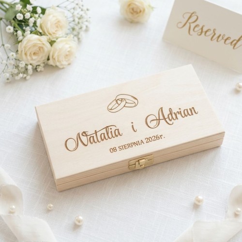 Personalizowane drewniane pudełko na pieniądze z grawerem imion Natalia i Adrian oraz datą ślubu, widok z góry na jasnym tle.