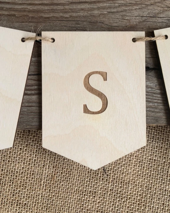 Personalizowany gładki drewniany proporczyk z grawerowaną literą do pokoju dziecka.