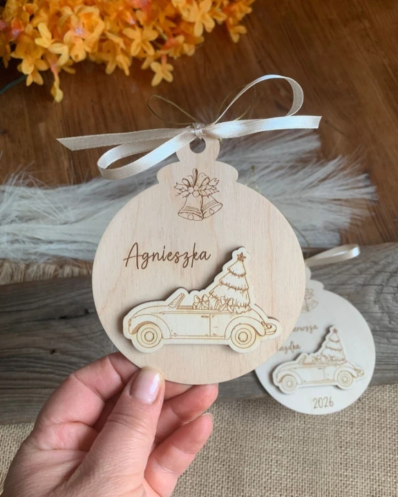 Personalizowana drewniana bombka choinkowa z imieniem Agnieszka i doklejonym autkiem z choinką.